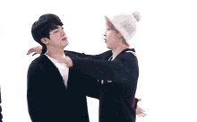 a group of young men are hugging each other and one of them is wearing a white hat