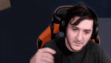 a man wearing headphones and covering his face with his hand