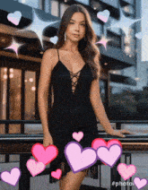 a woman in a black dress with pink hearts around her