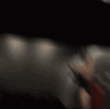 a blurred image of a man flexing his muscles in a gym