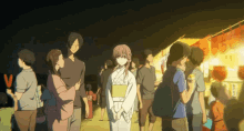 a woman in a kimono is standing in a crowd of people
