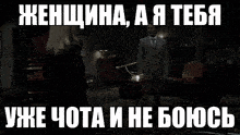 a woman in a black dress is standing in front of a window in a room with a caption in russian .
