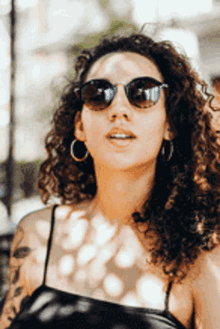 the woman is wearing sunglasses and hoop earrings
