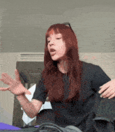 a woman with red hair wearing a black shirt