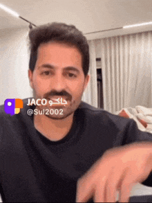 a man with a beard is wearing a black shirt that says jaco on it