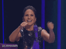 a woman in a sequined top is smiling and raising her hands in the air with the hashtag lialmeida05
