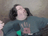 a man wearing headphones is sitting in front of a microphone and making a funny face .