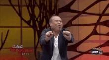 a man in a suit is pointing at the camera on a tv show called the shock .