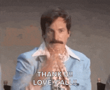a man with a mustache is holding his hands together and saying `` thank u ! love y 'all ! ''