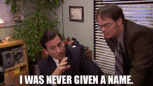 a man in a suit and tie is talking to another man in a room .