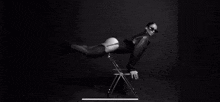 a woman is sitting on a folding chair with her legs crossed .