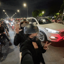 a woman wearing a helmet that says ' simpson ' on it stands in front of a crowd of people