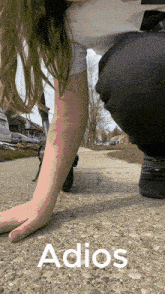 a person kneeling down with the word adios above them