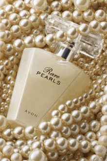 a bottle of avon rare pearls perfume is surrounded by pearls