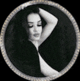 a black and white photo of a woman 's face in a circle .
