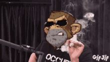 a man wearing a black shirt that says occupy is smoking a cigarette in front of a microphone