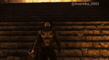 a man standing on a set of stairs with a fire in the background and the hashtag avantika0902