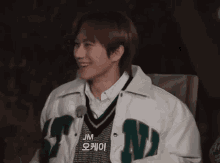 a young man wearing a white jacket with the letter n on it