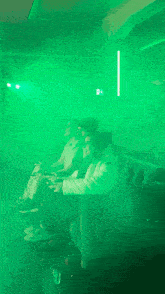 a group of people are playing a video game in a dark room