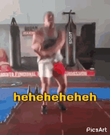 a man is dancing in a gym with the words ' heneheneh ' on the bottom right
