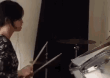 a woman is playing the drums in a room .