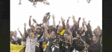 a group of soccer players are celebrating with a trophy in their hands