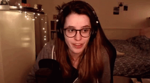 a woman wearing headphones and glasses is talking into a microphone .