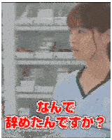 a woman in a blue scrub top is standing in front of a shelf with chinese writing .