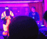 a man in a costume with glow in the dark eyes is standing on a stage