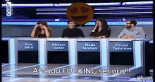 a group of people sitting at a table with the words " are you fucking serious "