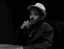 a man wearing a white hat with stars on it is giving a thumbs up