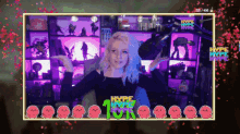 a woman stands in front of a screen that says hype lives 10k