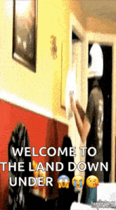 a man is standing in a room with the words welcome to the land down under