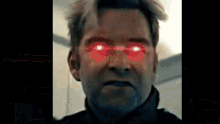 a close up of a man 's face with bright red eyes