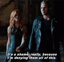 a man and woman are standing next to each other and the man is saying it 's a shame