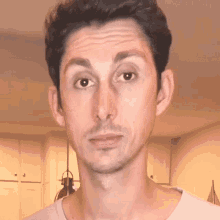 a man with a beard looks at the camera with a serious look on his face