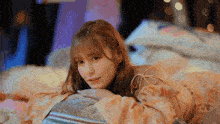 a young woman is laying on a bed with her head on a pillow