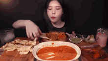 a woman is sitting at a table with a plate of food and a glass that says coca cola