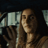 a woman is sitting in a car and smiling