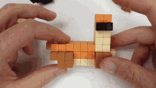 a person is holding a piece of lego that looks like a dog