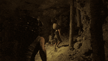 a person carrying a basket on their back walking through a cave