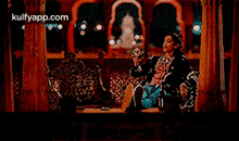 a man is sitting on a couch in a room holding a bottle of wine .