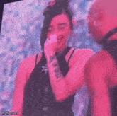a man and a woman are standing in front of a large screen .