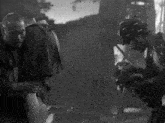a black and white photo of two men with one wearing a hat that says ' supreme ' on it