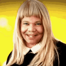 a woman with long blonde hair and a white collar smiles for the camera