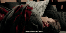 a man is laying in a bed with a pillow on his head and a blanket on his back .