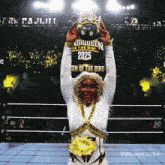 a woman is holding a trophy in front of a sign that says queen of the ring 2025