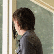a man in a striped shirt looks through a door