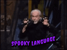 a man with a beard is giving a speech with the words spooky language above him