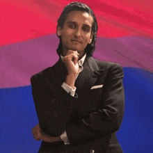 a man in a suit with his hand on his chin